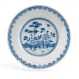 18TH C. ENGLISH DELFT DISH, probably Liverpool, painted with Chinese flowers in a fenced garden,