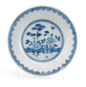 18TH C. ENGLISH DELFT DISH, probably Liverpool, painted with Chinese flowers in a fenced garden,