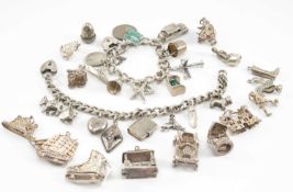 TWO SMALL SILVER CHARM BRACELETS, filled with 10 and 8 charms respectively, and 15 loose charms, tot