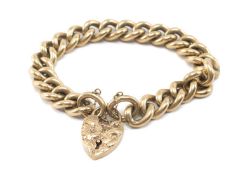 9CT GOLD CHUNKY CURB LINK BRACELET, engraved flower head heart shaped padlock, 63.6gms Provenance: