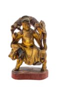 CHINESE LACQUERED WOOD FIGURE, Qing Dynasty, seated on a tiger and grasping the beard of a chilong