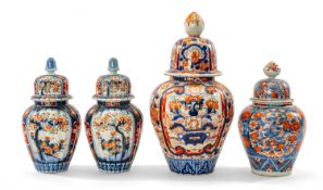 FOUR JAPANESE IMARI RIBBED VASES & COVERS, the smaller pair painted with panels of flowering