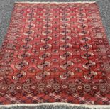 EASTERN WOOLLEN RUG with deep red ground and repeating floral motif throughout, 204cms L x 190cms W