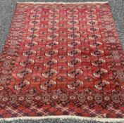 EASTERN WOOLLEN RUG with deep red ground and repeating floral motif throughout, 204cms L x 190cms W