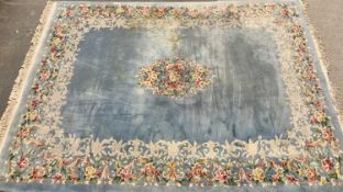 CHINESE WASHED WOOLEN RUG being a large example, blue ground with floral border and central motif,