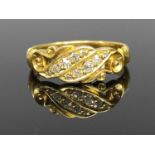 EDWARDIAN 18CT GOLD DIAMOND RING having a twist scroll mount set with ten small round cut diamonds