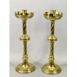 A PAIR OF SUBSTANTIAL VICTORIAN GOTHIC STYLE BRASS ALTAR CANDLESTICKS with crenulated drip pans,