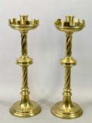 A PAIR OF SUBSTANTIAL VICTORIAN GOTHIC STYLE BRASS ALTAR CANDLESTICKS with crenulated drip pans,