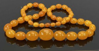 AMBER BEAD NECKLACE HOLDING 47 GRADUATING BEADS, 30mm across (the largest), 10mm across (the