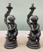 PAIR OF COMPOSITION CHERUBIC BLACK LAMPS, the figures seated holding leaf form fitting mounts on