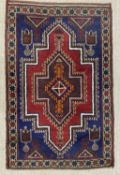 EASTERN STYLE WOOLLEN RUG, red and blue ground, with central stepped block pattern, diamond