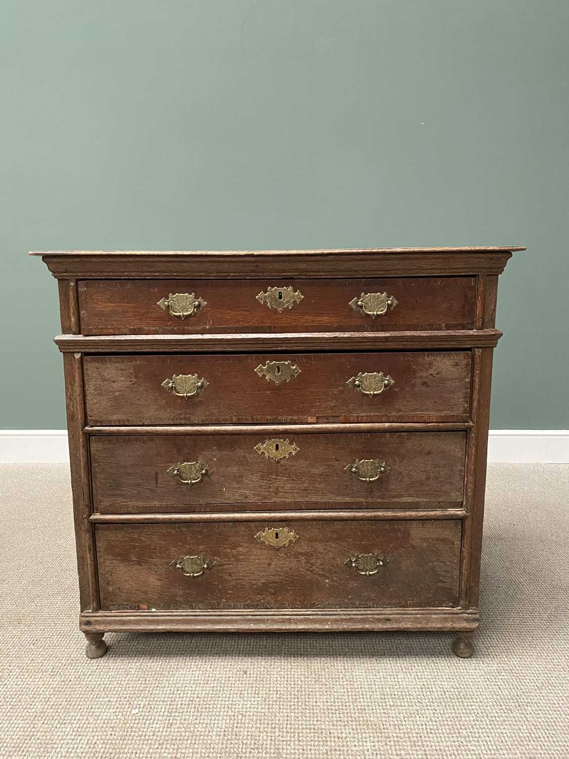 GEORGIAN OAK CHEST of four long crossbanded oak lined drawers, with later brassware, panel sided