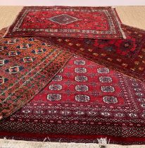 FOUR ORIENTAL RUGS, including Bokhara, Afghan, Baluch and a Tribal Shiraz, largest rug 240 x 160cms,