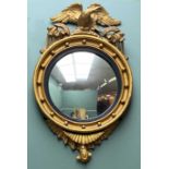 REGENCY STYLE GILTWOOD CONVEX MIRROR, reeded ebonised slip, eagle cresting, 75cms h Comments: cracks