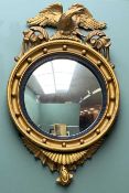 REGENCY STYLE GILTWOOD CONVEX MIRROR, reeded ebonised slip, eagle cresting, 75cms h Comments: cracks