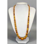 VINTAGE AMBER BEAD NECKLACE OF 58 GRADUATING BEADS, 17mm across (the largest), 6mm across (the