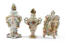 TWO SITZENDORF URNS & MIRROR, all typically encrusted with flowers, one with amorini handles 34cms