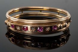 VICTORIAN YELLOW GOLD BANGLE set with graduated rubies and diamond chips, unmarked, 16.0gms