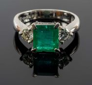 PLATINUM EMERALD & DIAMOND THREE STONE RING, the central claw set emerald (1.3cts approx.) flanked