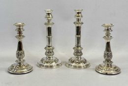 TWO PAIRS OF EPNS CANDLESTICKS, extending type and fixed, both having embossed decorations on loaded