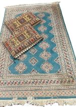 EASTERN WOOLEN RUG & TWO CUSHIONS, the rug being turquoise ground with repeating panel central block