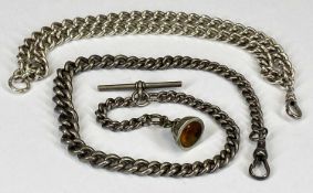 TWO SILVER CURBLINK ALBERT CHAINS, PROBABLY 19TH CENTURY, one with fob containing a yellow stone