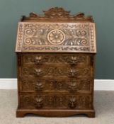 HEAVILY CARVED OAK BUREAU, having a shaped crest-rail, deep floral carved front fall opening to
