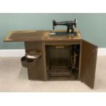 VINTAGE SINGER TREDLE SEWING MACHINE, in a work station cabinet, having a foldover top and twin