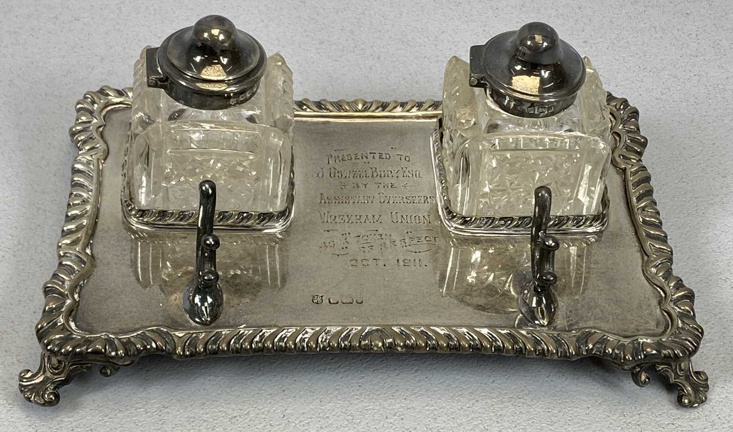 EDWARD VII SILVER INKSTAND of shaped rectangular form, with gadrooned border and scroll feet, with