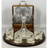 REPRODUCTION MAHOGANY TRAY with brass gallery holding a cut glass ship's decanter and stopper, 26cms