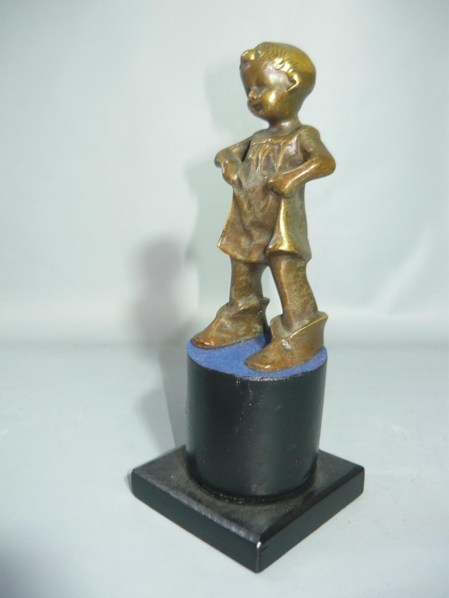 Kleines Mädchen im Kleid und zu großen Schuhen. Bronze auf Sockel. H. 20cm.