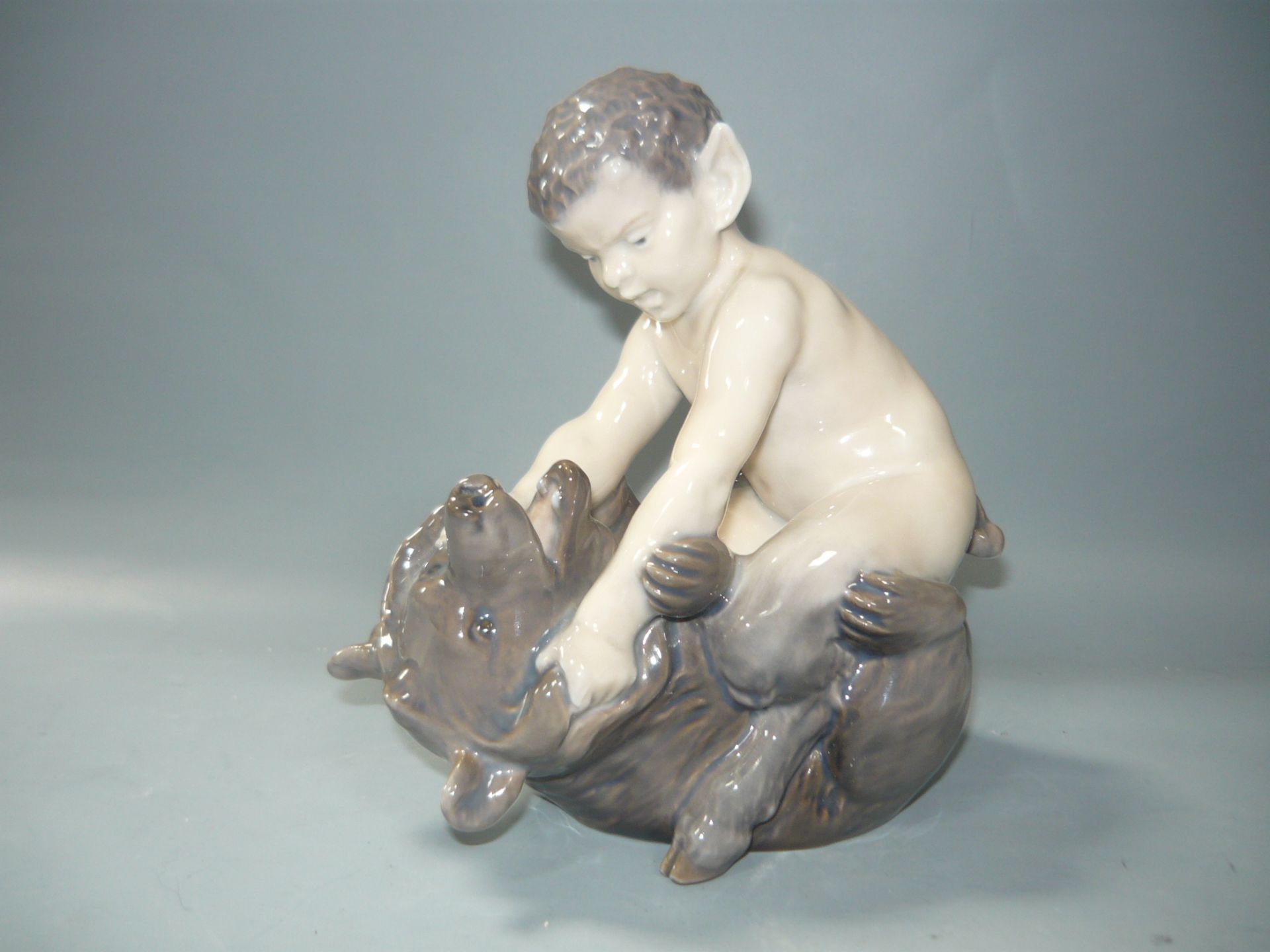 Royal Copenhagen. Faun mit Bär. Zweite Wahl. H. 17cm. //English: Satyr with Bear. Handpainted.