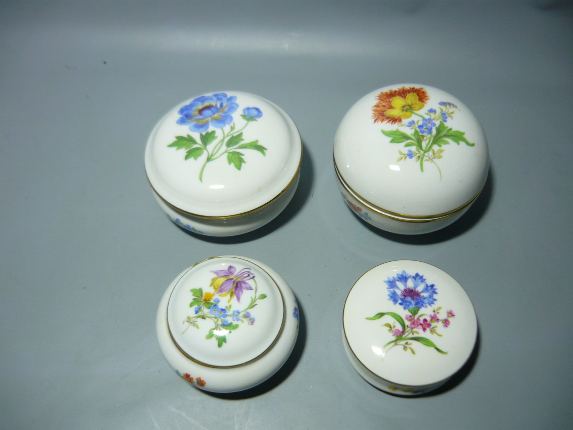 Meissen (Schwerter). Kleine Sammlung Deckeldosen mit Blumenmalereien. Zweite Wahl. Ø ca 7-10cm. /