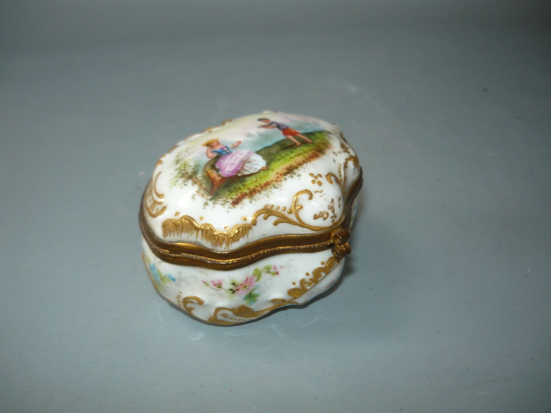 Antike Deckeldose mit Szenerie. Innen üppig vergoldet. Faux-Meissen-Marke. L. 8cm. //English: