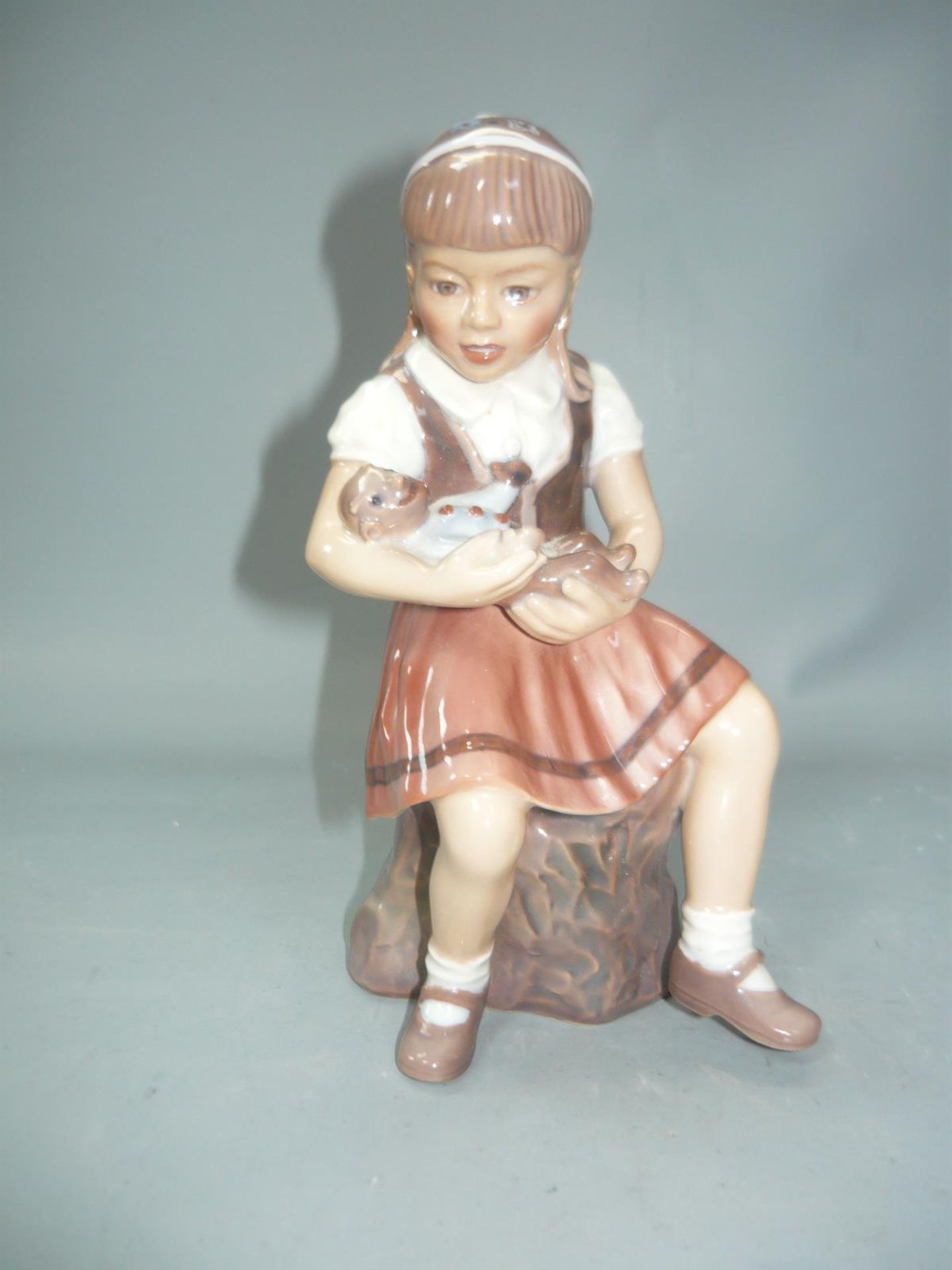 Dahl Jensen, Dänemark. Seltener sitzendes Mädchen mit Puppe. Schleifstrich. H. 15cm. //English: Dahl