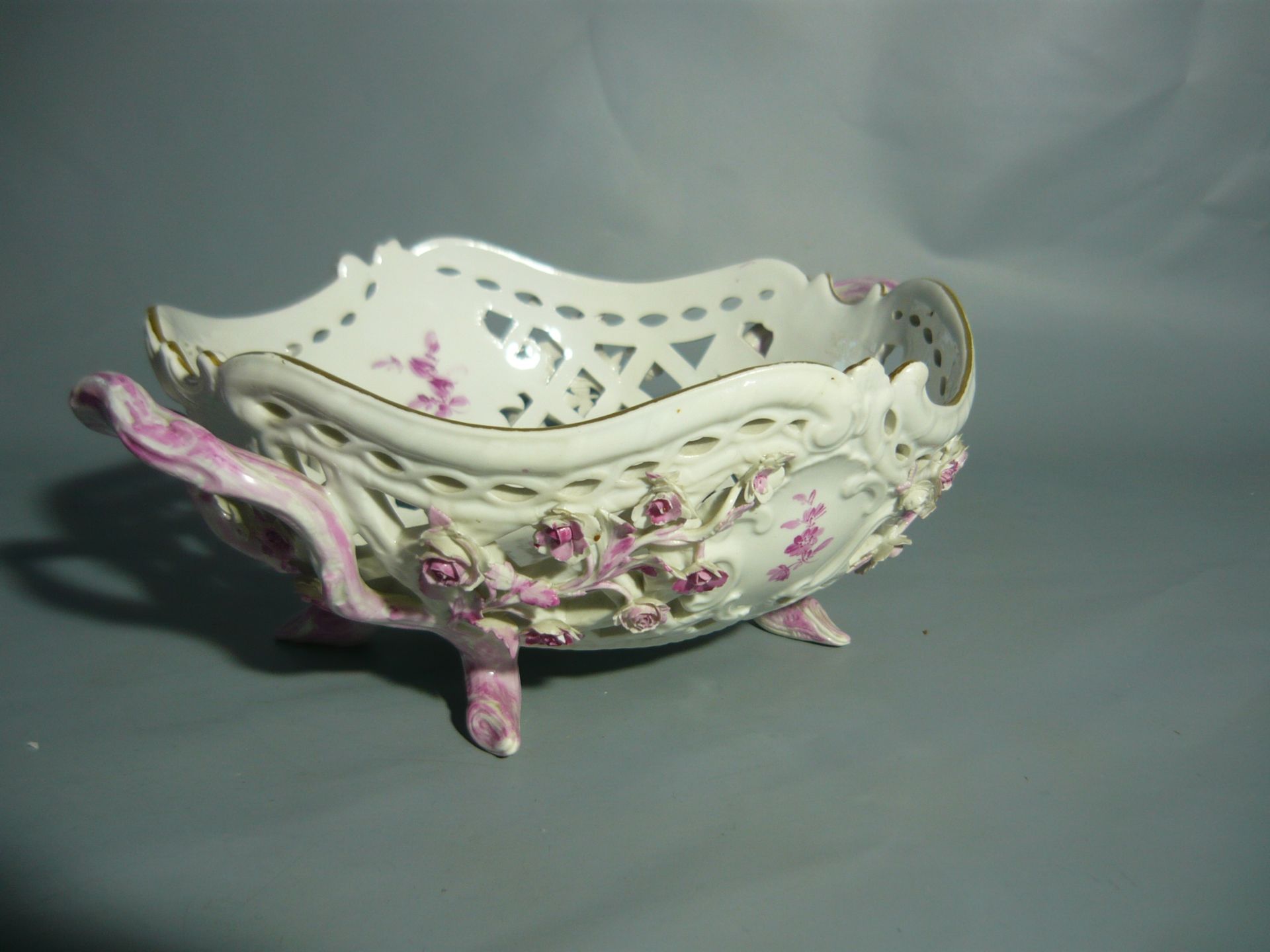 Meissen (Schwerter). Henkelkorb auf vier Füßen. Zahlreiche Blüten. II.W. Antik. Ca. 25x21x10cm.