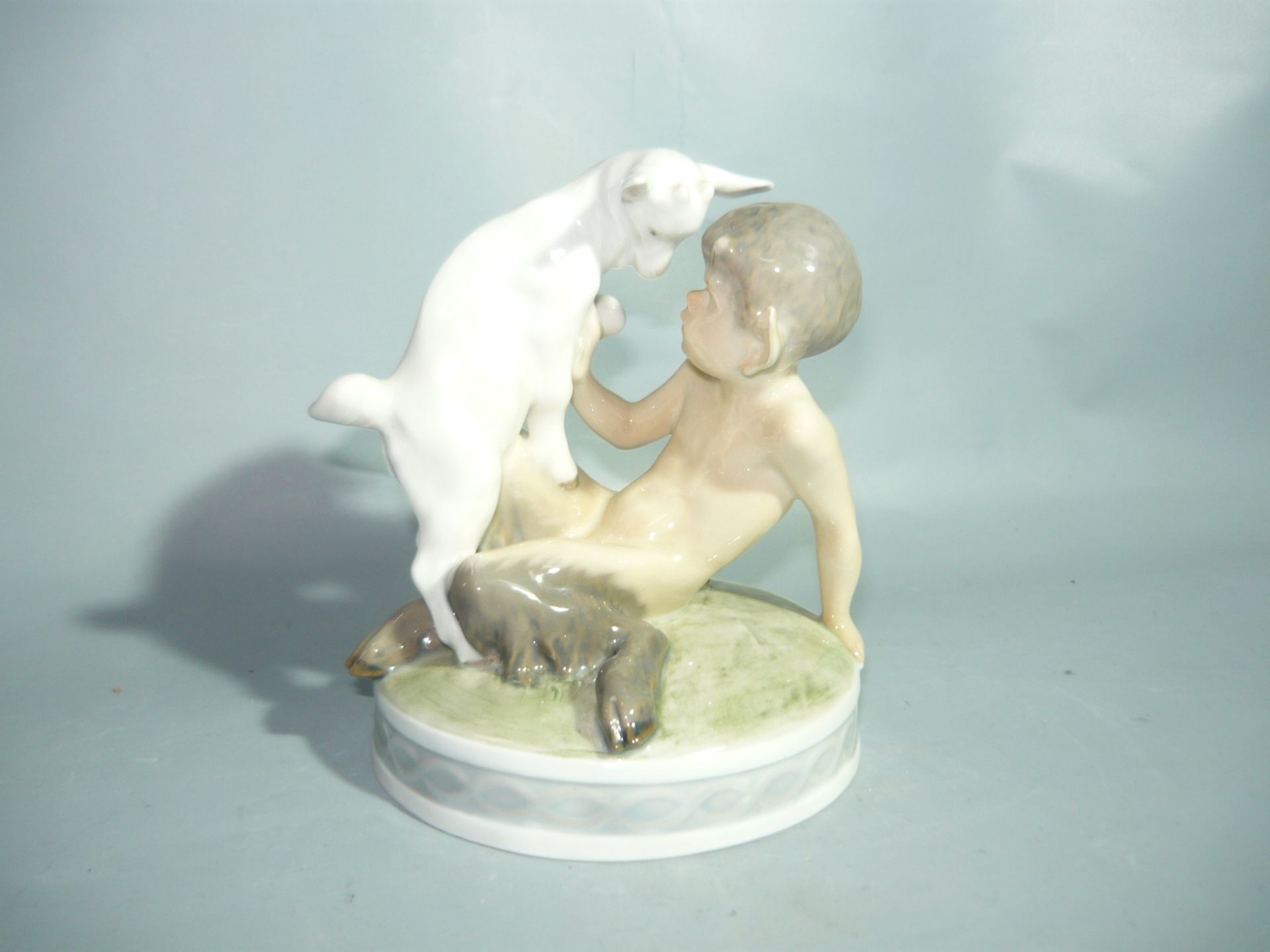 Royal Copenhagen. Sitzender Faun mit Ziege. Erste Wahl. H. 13cm. //English: Royal Copenhagen.