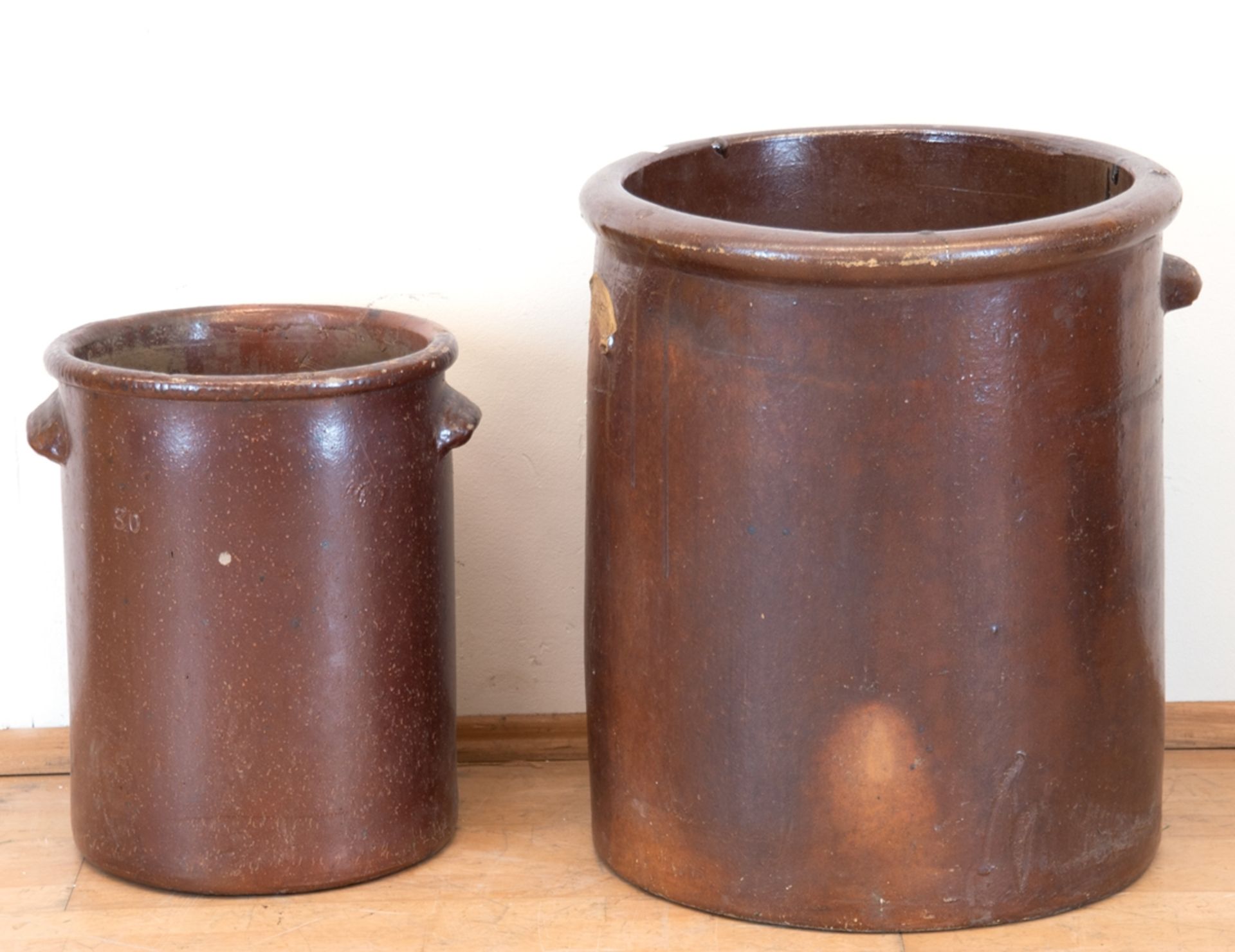 2 Steinzeugtöpfe/ Kübel, rotbraune Glasur, 1 Henkel fehlt, Gebrauchspuren, H. 44,5 cm, Dm. 31 cm un
