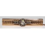 Brillant-Brosche um 1900, 585er GG, besetzt mit 1 Brillant von ca. 0,18 ct. und 12 Diamantrosen, mi