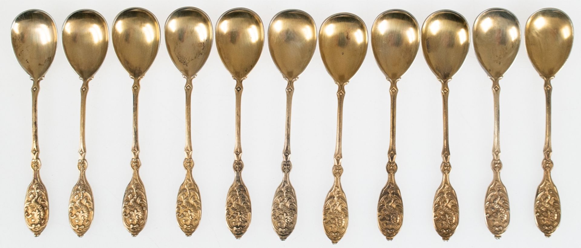 11 Mokka-Löffel, 800er Silber vergoldet, reich reliefiert, rücks. Monogramm "TD", ges. 120 g, im Et