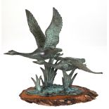 Figurengruppe "Zwei fliegende Schwäne", Bronze grün patiniert, auf Holzscheibe, H. 26,5 cm