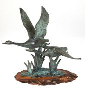 Figurengruppe "Zwei fliegende Schwäne", Bronze grün patiniert, auf Holzscheibe, H. 26,5 cm