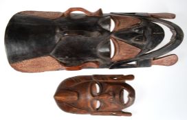 2 Masken, Afrika, Holz geschnitzt, davon 1x farbig gefaßt, L. 27 cm (mit Rissen) und 60 cm