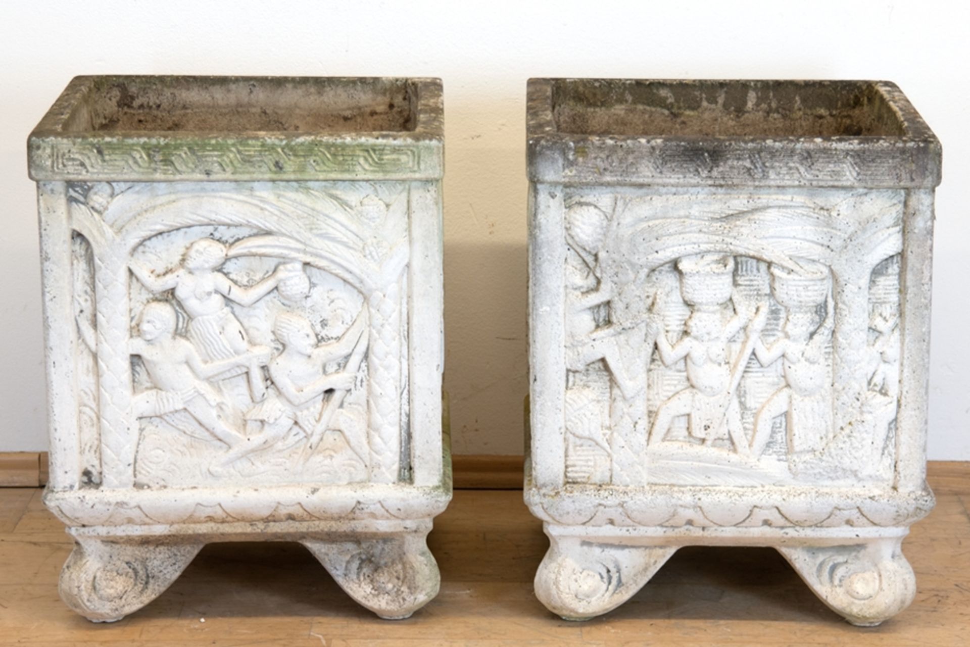 Paar Pflanzkübel, Steinguß, quadratisch, mit umlaufendem figürlichem Relief, auf 4 Volutenfüßen, Ge