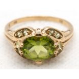 Ring, 375er GG, durchbrochener Ringkopf besetzt mit oval facettiertem Peridot und seitlich 8 kleine