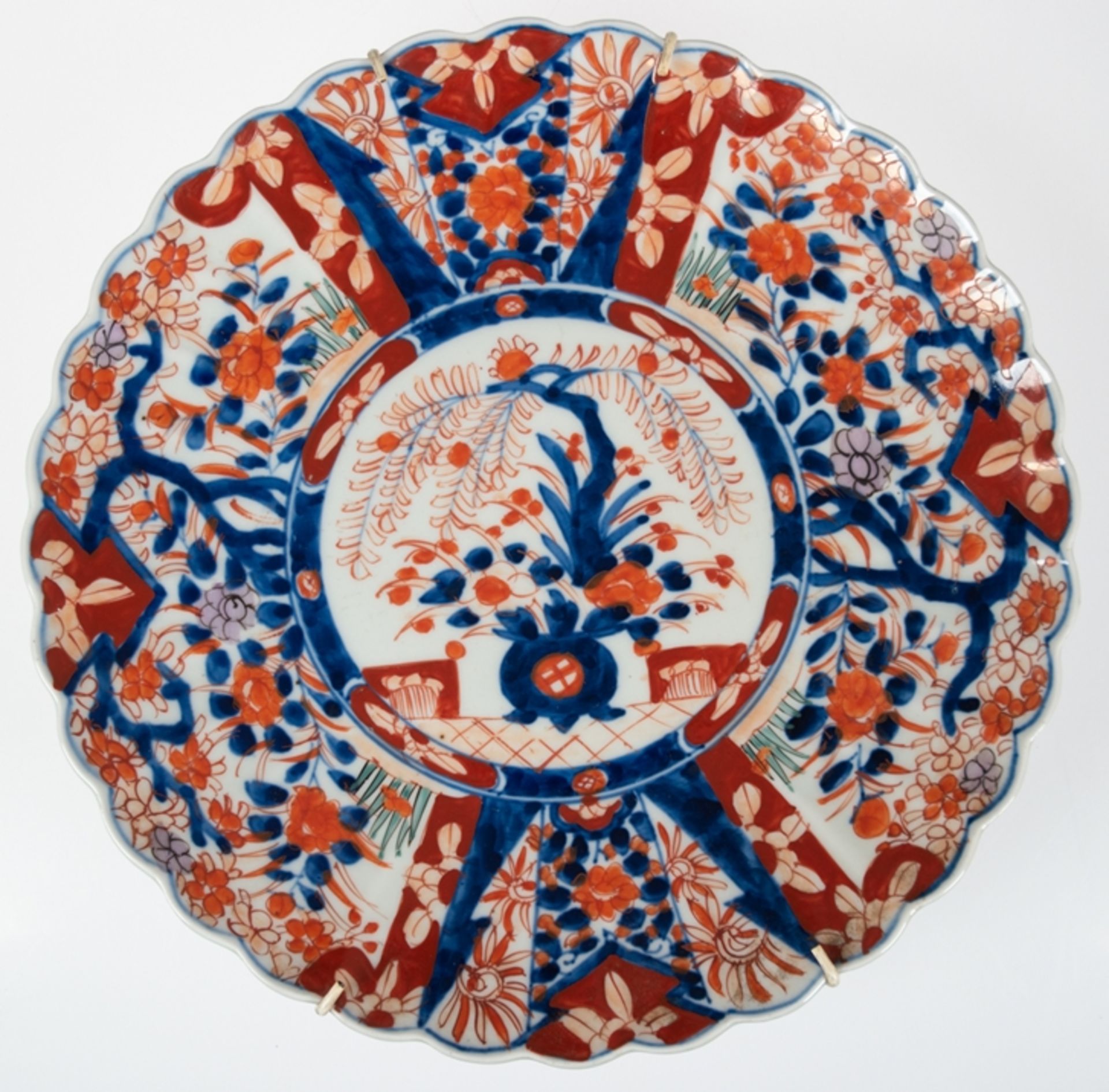 Imari-Teller, Japan 19. Jh., Dekor in Kobaltblau und Rot, Spiegel und Ränder mit Blumenarrangement,