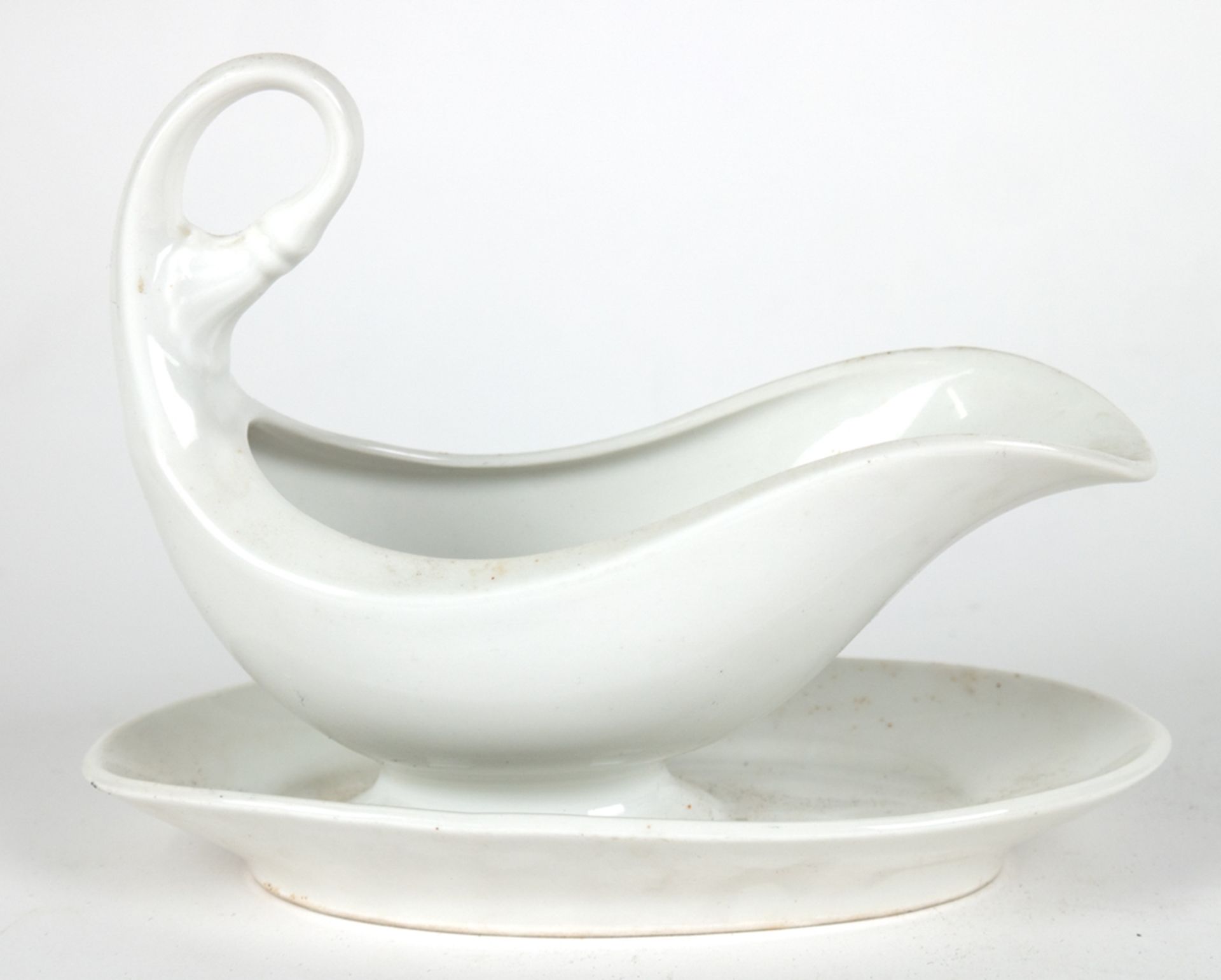 KPM-Sauciere auf festem Unterteller, weiß, hochgezogener Henkel, Rand etwas best., H. 16 cm, L. 21