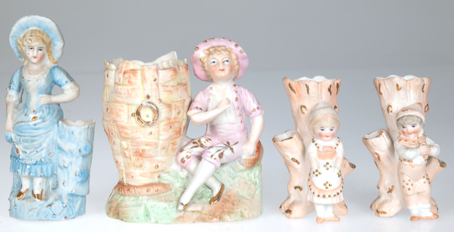 4 diverse Biskuitporzellan-Figuren an Gefäß (Vase) stehend, polychrom bemalt mit Goldstaffage, H. 1