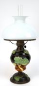 Jugendstil-Petroleumlampe, Majolika-Korpus mit Glas-Petroleumbehälter, auf rundem Metallfuß, mit fa