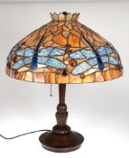 Tischlampe im Tiffanystil, Ende 20. Jh., 2-flammig, auf rundem, gegliedertem Eichenfuß, Schirm aus 